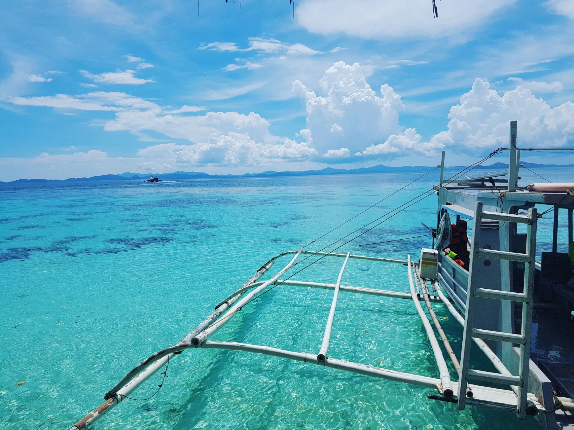 Private bangka outrigger on crystal clear turquoise water, private tours Philippines