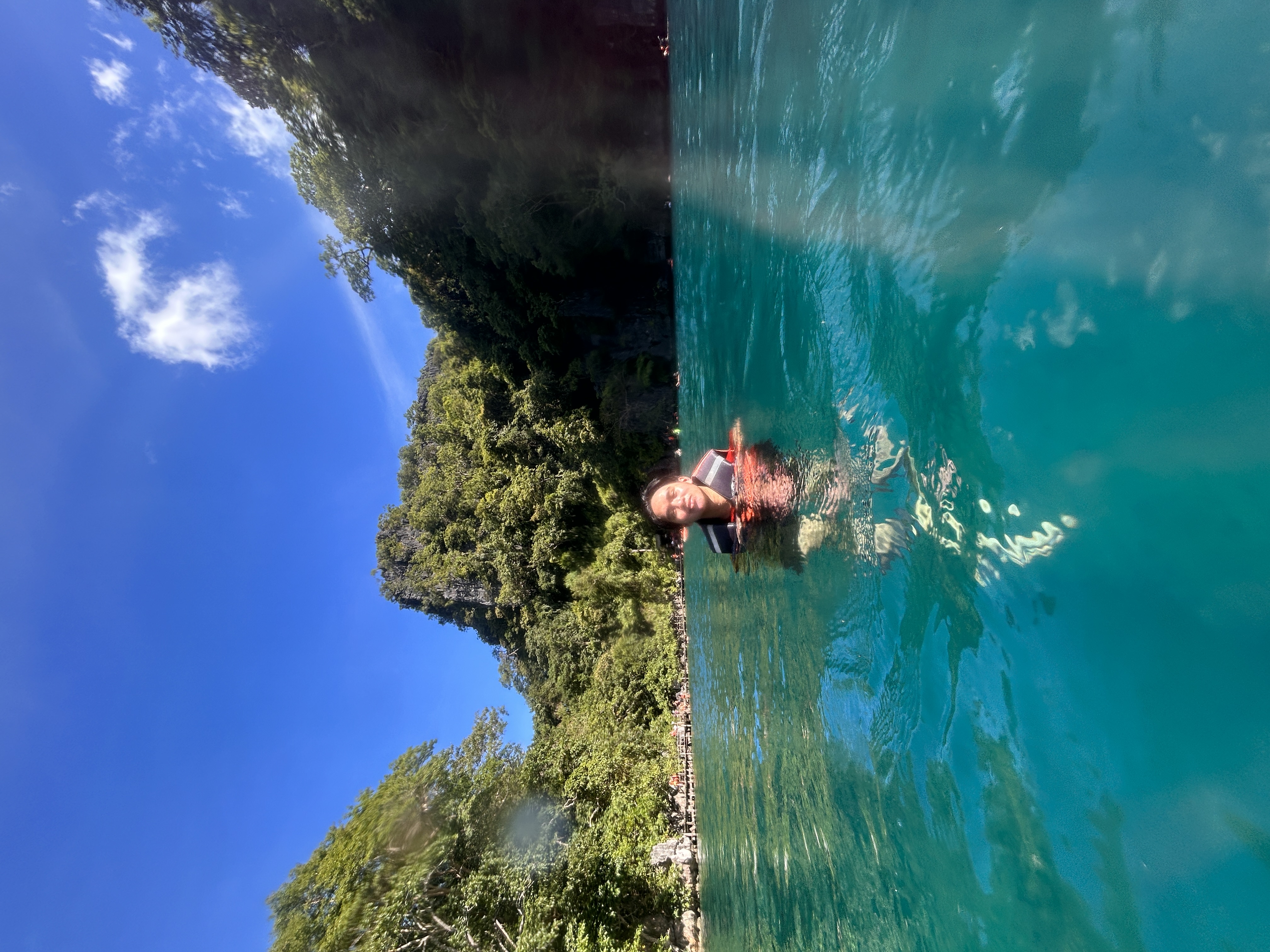 Swimming in Kayangan Lake, Coron Island — teal water, limestone karsts and forest behind