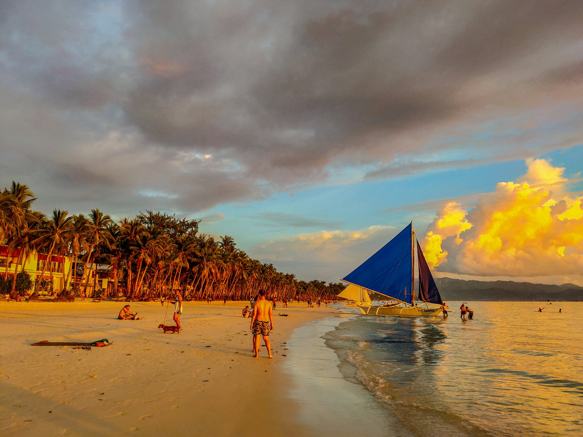 Golden hour sunset beach Philippines sailing paraw boat luxury travel